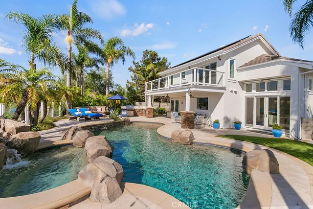 a view of a white house with a big yard and potted plants