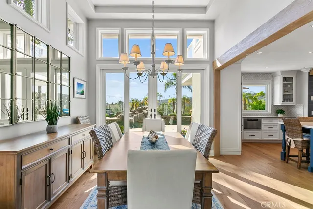 a view of a dining room with furniture a chandelier and wooden floor