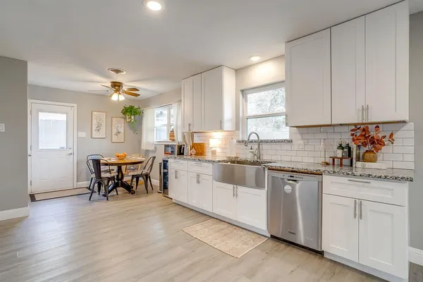 a kitchen with white cabinets sink and stove