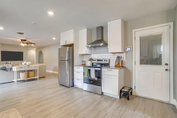a kitchen with a refrigerator and a stove top oven