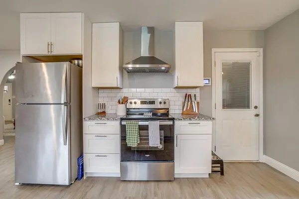 a kitchen with a stove refrigerator and a window