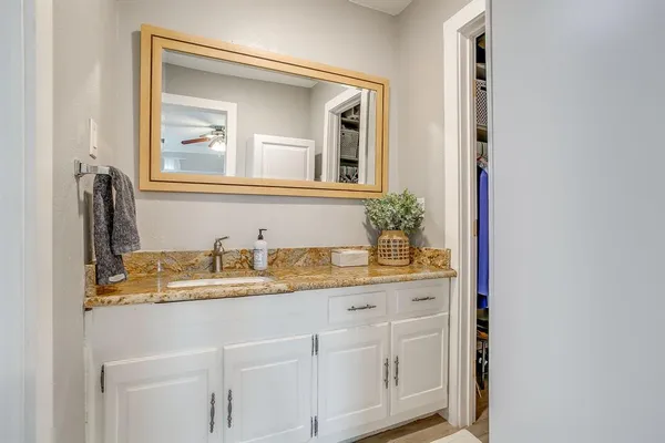 a bathroom with a granite countertop sink and a mirror