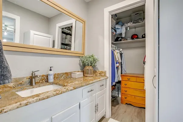 a bathroom with a granite countertop sink and a mirror