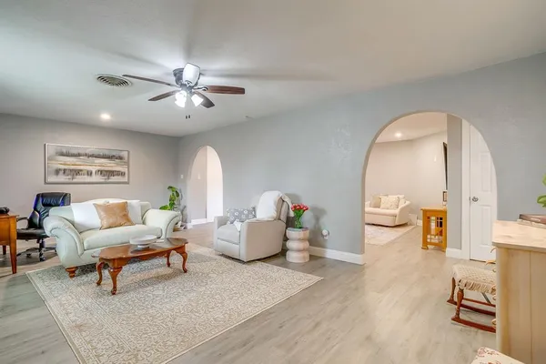 a living room with furniture and a wooden floor