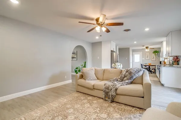 a living room with furniture and a view of kitchen
