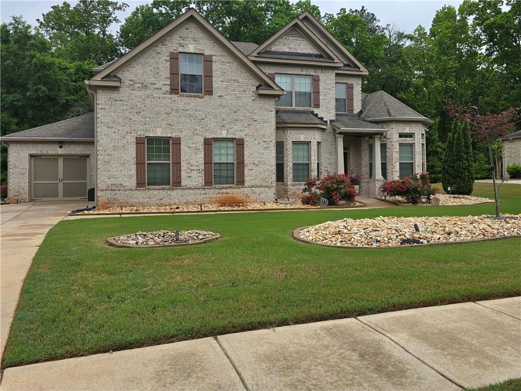 6856 Louis Drive Locust Grove, GA 30248 - Photo 1 of 17 a front view of a house with a yard table and chairs