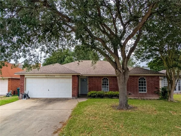 a front view of a house with a garden and trees