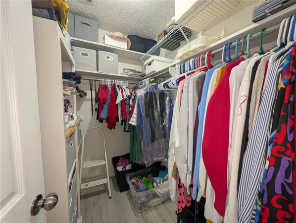 a view of walk in closet with clothes