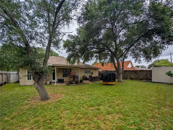 a view of a house with a big yard and large trees