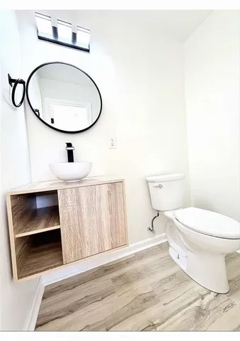 a bathroom with a toilet a sink and a mirror