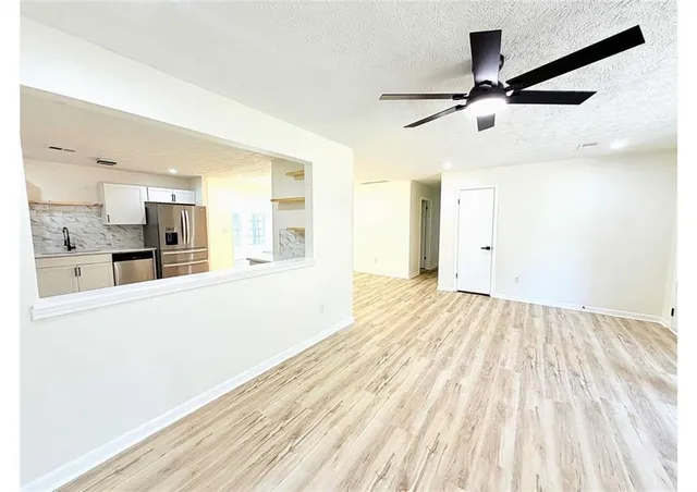a view of a kitchen with wooden floor and a ceiling fan