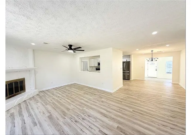 a view of empty room with wooden floor and fireplace