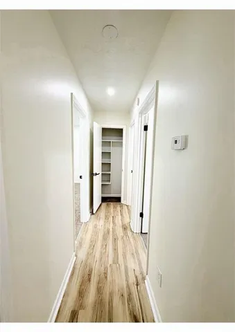 a view of a hallway with wooden floor