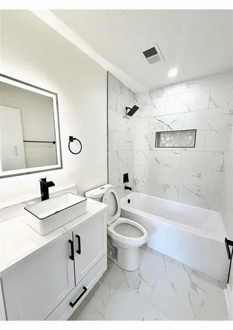a bathroom with a sink a toilet and bathtub