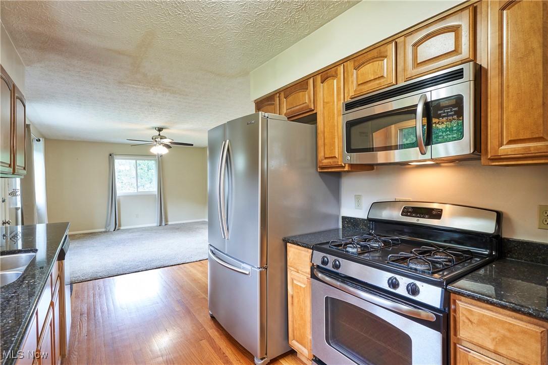 206 Benson Road Akron, OH 44333 - Photo 6 of 27 Kitchen with stainless steel appliances, wood floors and maple cabinets . The kitchen opens to the family room