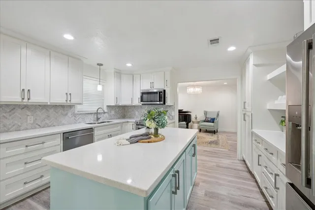 a large kitchen with stainless steel appliances a lot of counter space and wooden floor