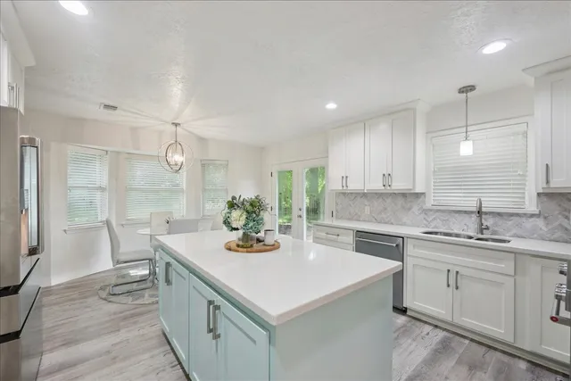 a kitchen with a sink a stove a refrigerator and cabinets
