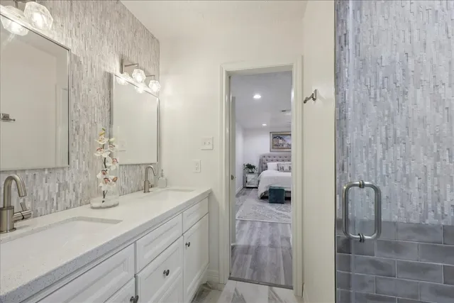 a bathroom with a double vanity sink a mirror and a shower