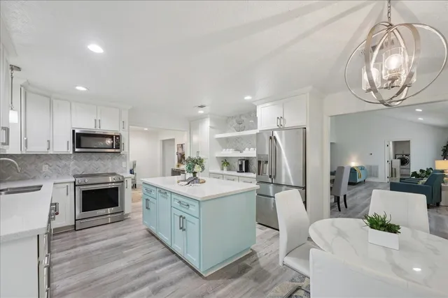 a kitchen with stainless steel appliances granite countertop a stove refrigerator and a sink