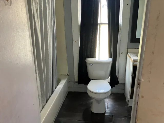 a white toilet sitting in front of a bathroom