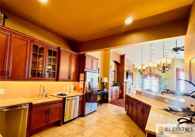 a large kitchen with stainless steel appliances granite countertop a stove a sink and a refrigerator