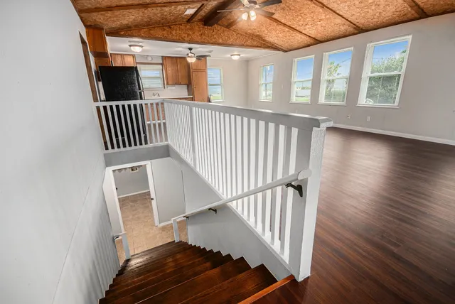 wooden floor with staircase and windows