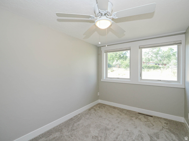 154 East 3000th Street South Bountiful, UT 84010 - Photo 19 of 37 Room featuring light neutral wall paint, two large windows with white trim, a ceiling fan with integrated lighting, and gray carpeting