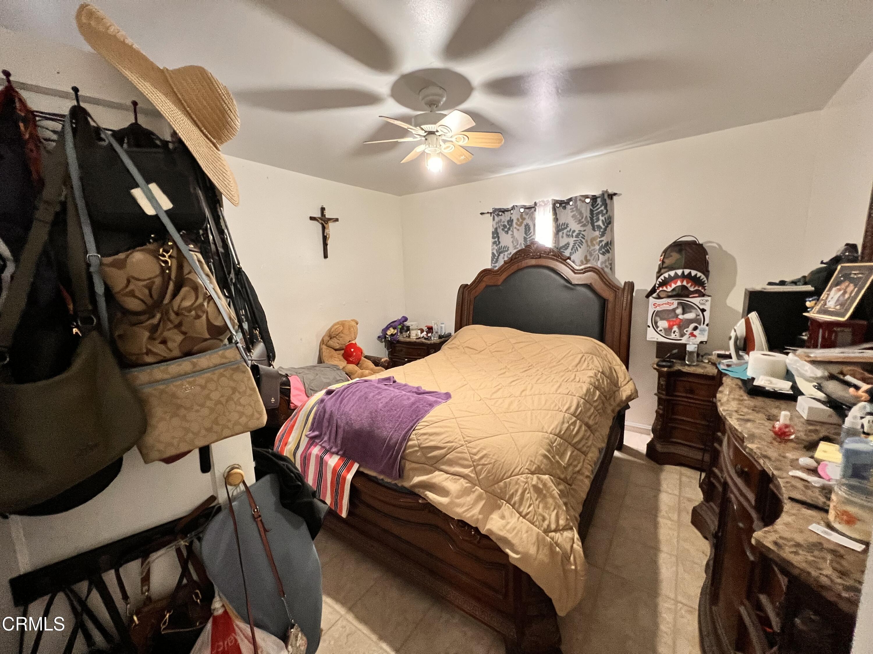 1017 King Street Oxnard, CA 93030 - Photo 12 of 22 a bedroom with a bed and a chandelier