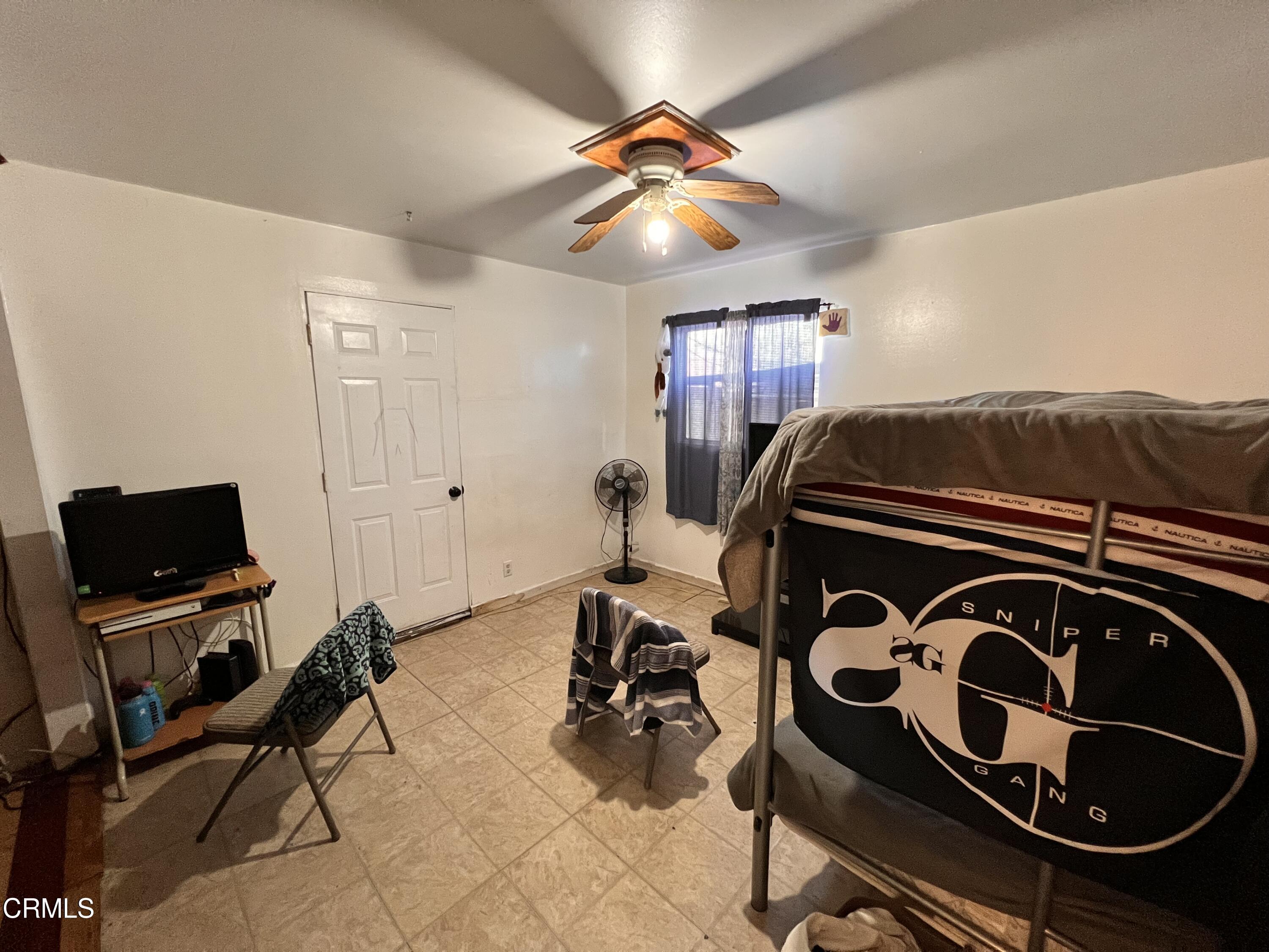 1017 King Street Oxnard, CA 93030 - Photo 13 of 22 a bedroom with a bed and a chandelier