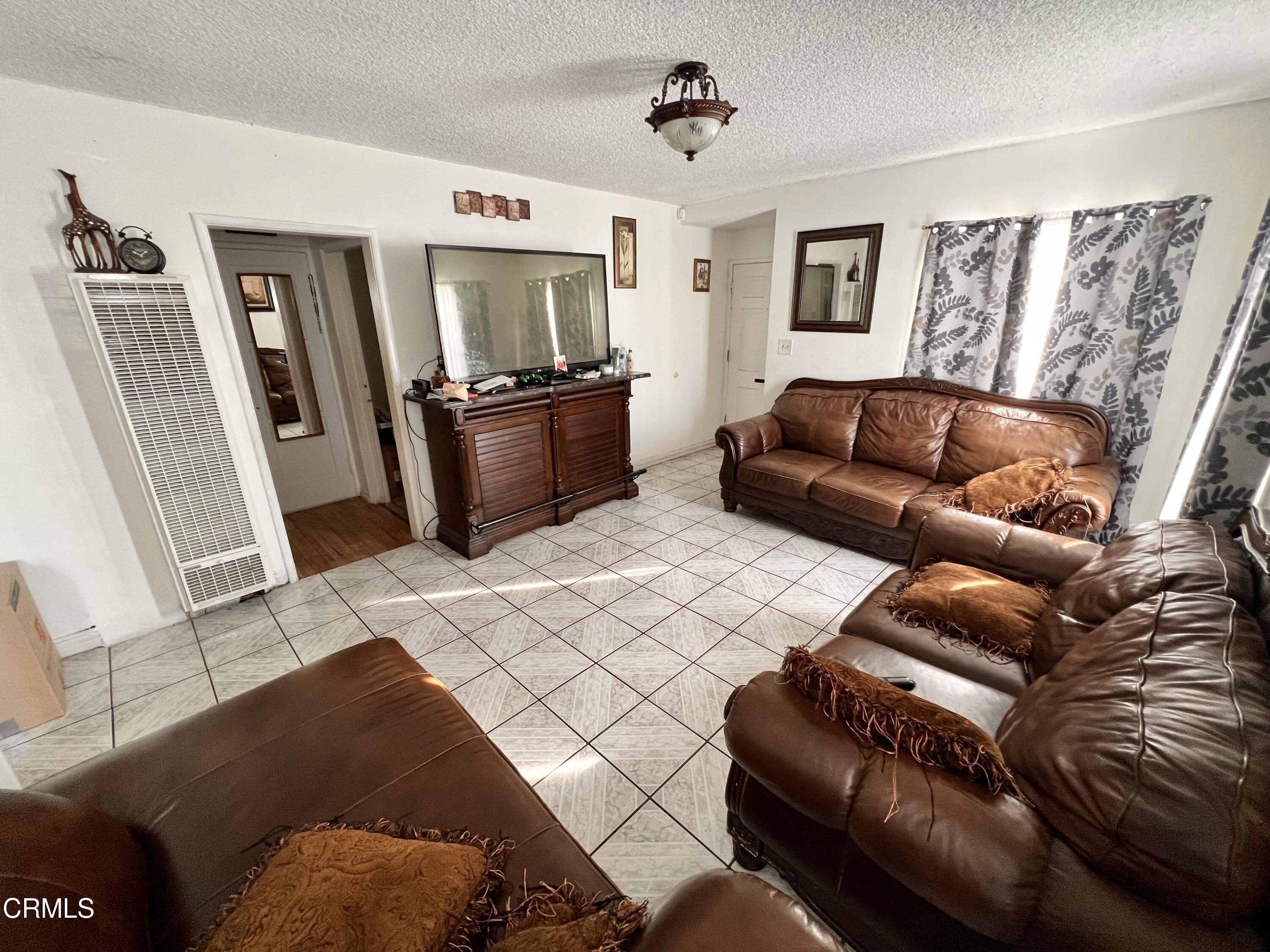 1017 King Street Oxnard, CA 93030 - Photo 9 of 22 a living room with furniture and a flat screen tv