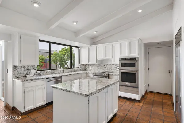 a kitchen with white cabinets and sink