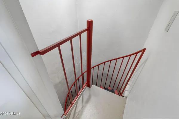 a view of a white house next to a yard with a large tree