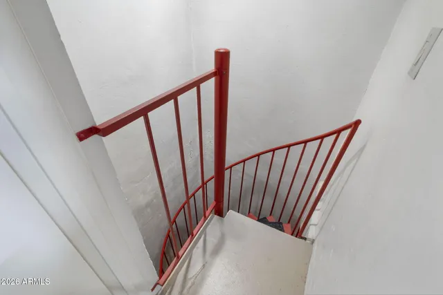 a view of a white house next to a yard with a large tree