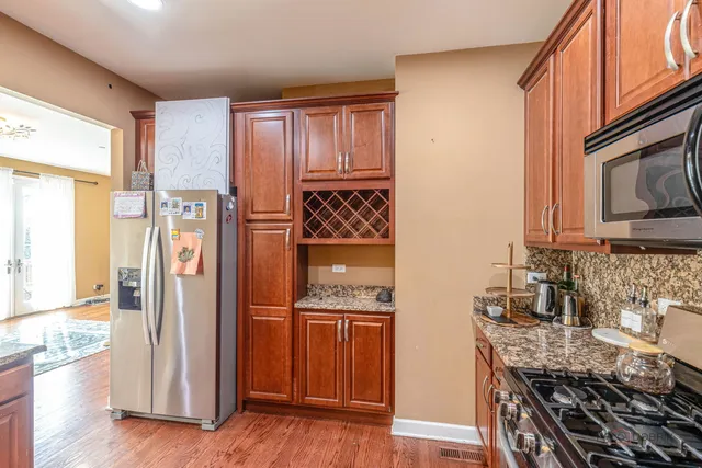 a kitchen with stainless steel appliances granite countertop a refrigerator and a stove top oven