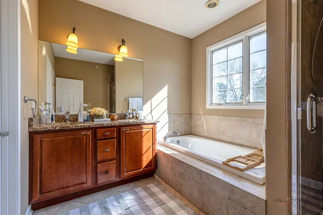 a bathroom with a granite countertop sink a mirror and a bathtub