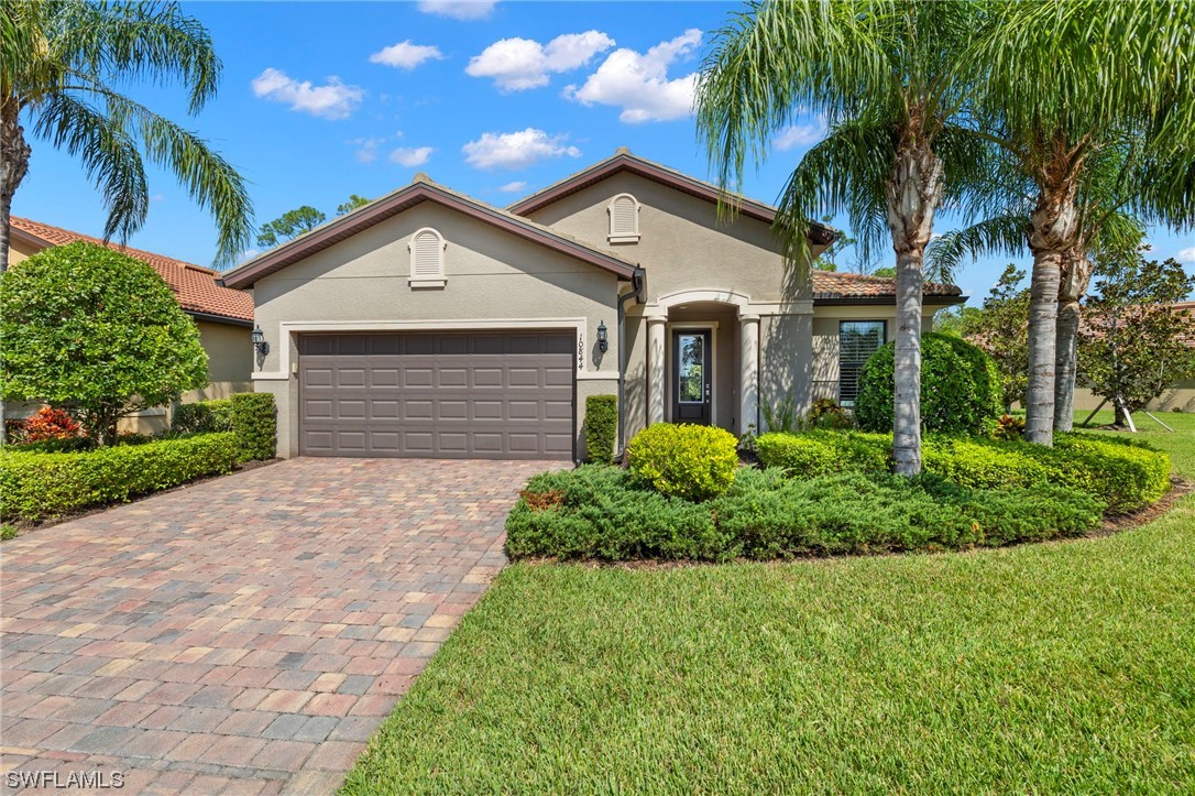 10844 Dennington Road Fort Myers, FL 33913 - Photo 2 of 50 a front view of a house with a yard and palm trees