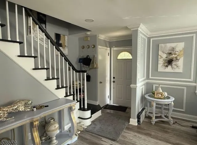 a view of a hallway with wooden floor and staircase