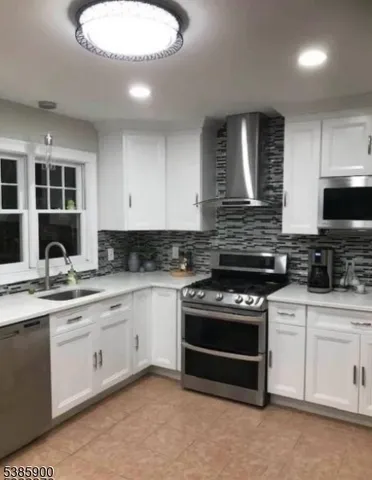 a kitchen with stainless steel appliances granite countertop a stove sink and cabinets