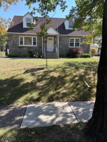 a view of a yard in front of a brick house with a large tree