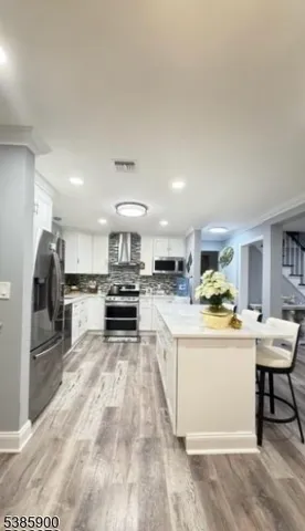 a kitchen with stainless steel appliances kitchen island granite countertop a sink stove and refrigerator
