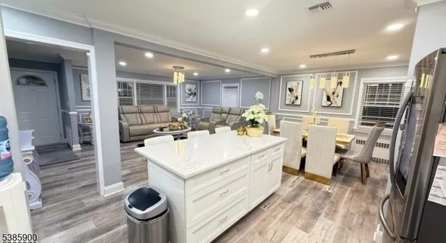 a large white kitchen with a sink and dishwasher a stove with wooden floor