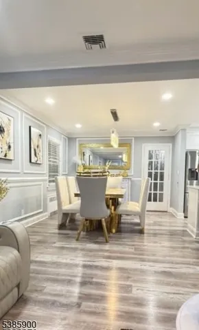 a living room with couches and kitchen view with wooden floor