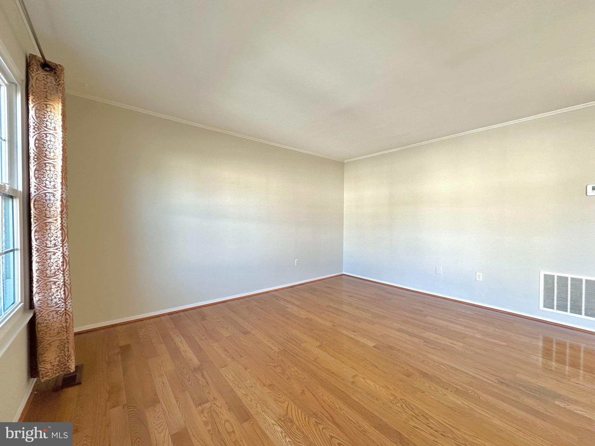 402 Carousel Court Gaithersburg, MD 20877 - Photo 4 of 29 a view of an empty room with wooden floor and a window