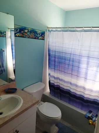 a bathroom with a sink a toilet and shower curtain
