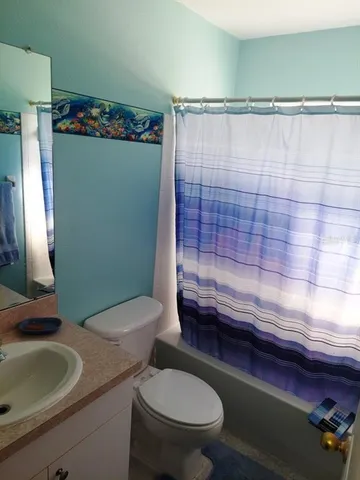 a bathroom with a sink a toilet and shower curtain