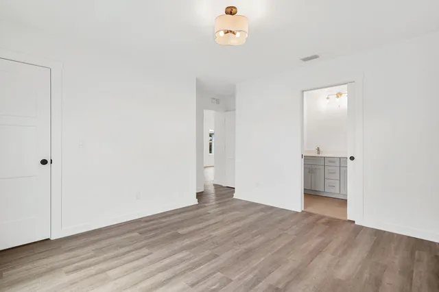an empty room with wooden floor and mirror