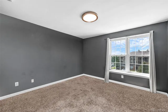 an empty room with windows and closet