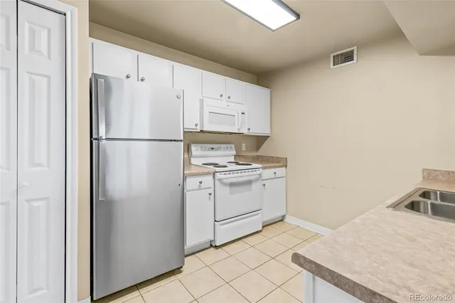 a white refrigerator freezer and a stove sitting inside of a kitchen