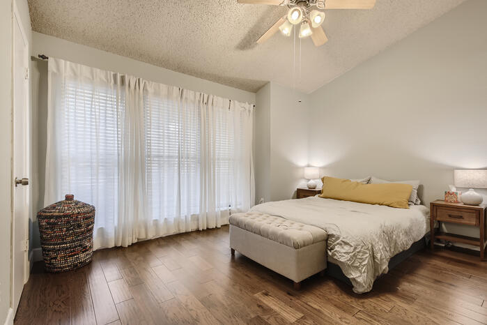 5107 Leralynn Street, Unit 304 Austin, TX 78751 - Photo 21 of 28 Bedroom featuring wood finished floors, a textured ceiling, vaulted ceiling, and a ceiling fan
