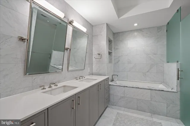 a bathroom with a double vanity sink mirror and shower